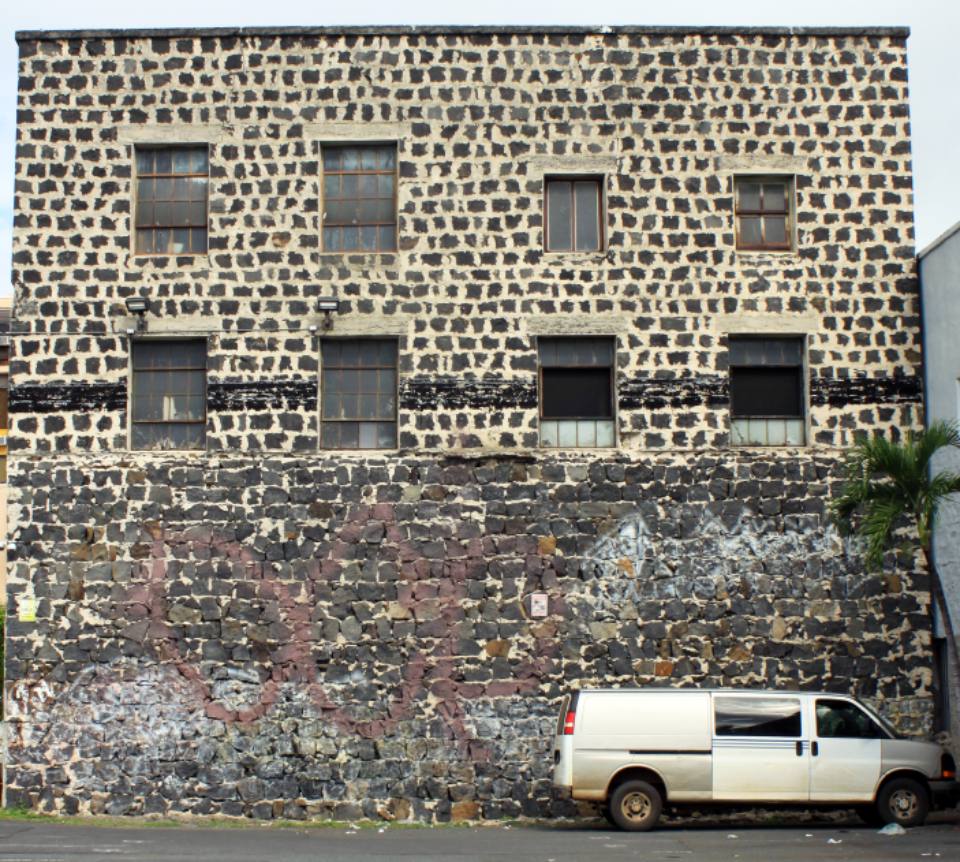 A white van parked beside a stone building